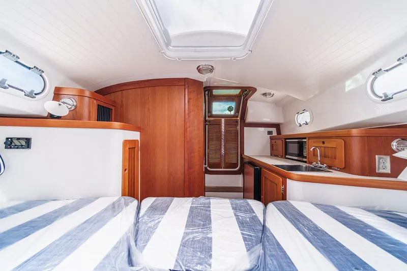 Slide: The Image of Interior of 2020 Hunt Yachts Surfhunter 32 with striped bedding and wooden cabinetry. - 53