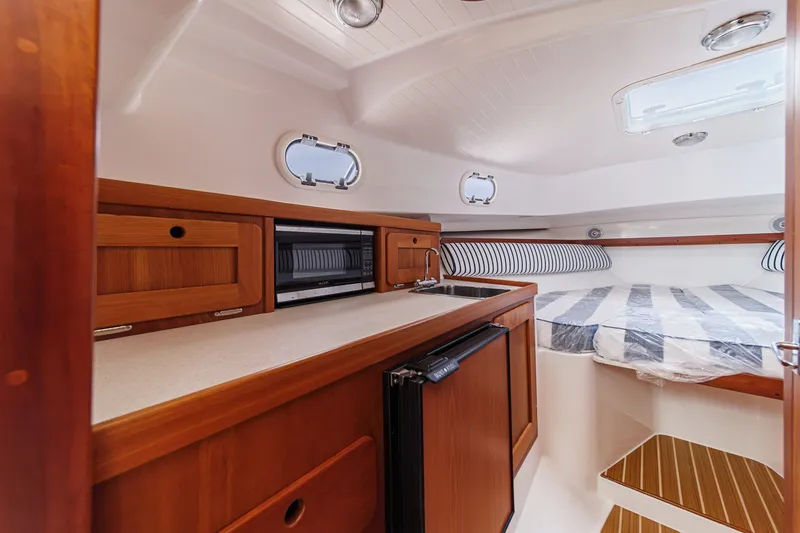 Slide: The Image of 2020 Hunt Yachts Surfhunter 32 cabin interior with kitchenette and cozy sleeping area. - 47