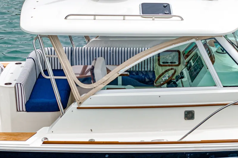 Slide: The Image of 2020 Hunt Yachts Surfhunter 32 with striped seating and wooden accents on the water. - 29