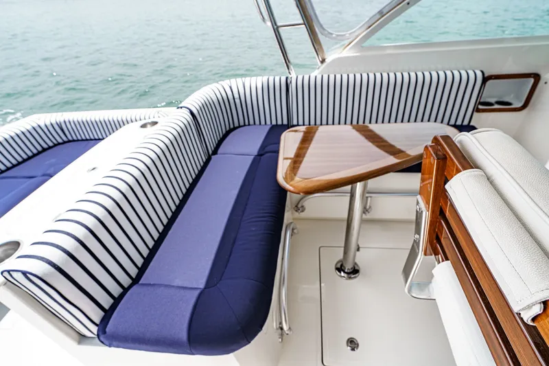 Slide: The Image of Elegant seating area on 2020 Hunt Yachts Surfhunter 32 with striped cushions and wooden table. - 44