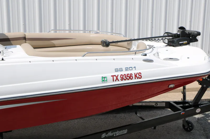 Slide: The Image of 2022 Hurricane SunDeck Sport 201 IO boat on trailer, red and white exterior. - 9
