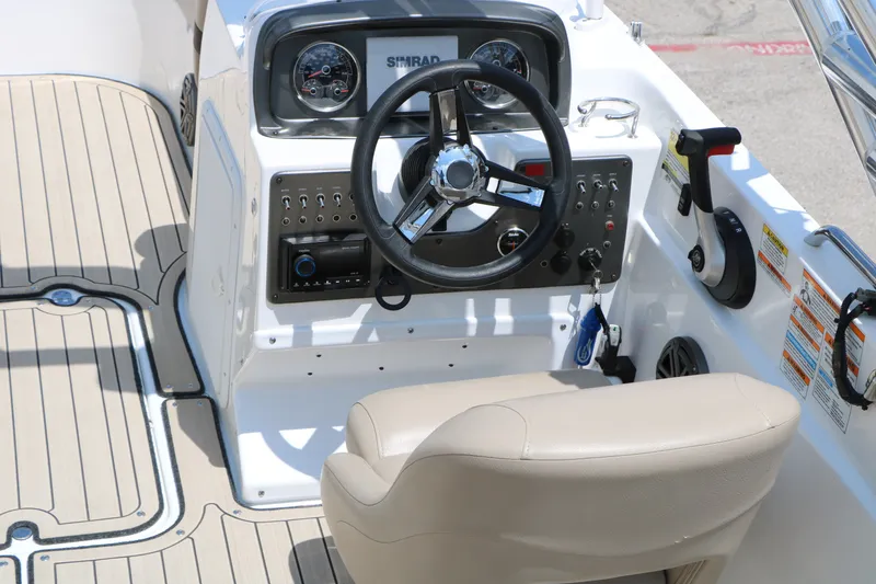 Slide: The Image of 2022 Hurricane SunDeck Sport 201 IO boat cockpit with steering wheel and control panel. - 15