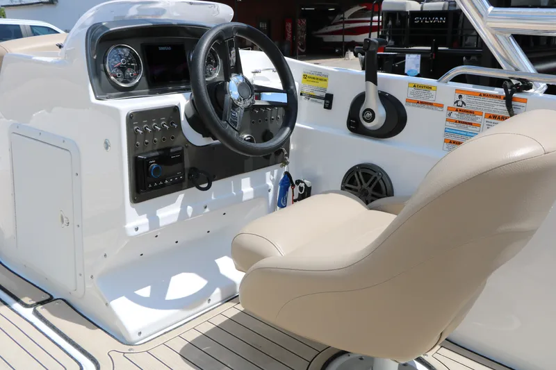 Slide: The Image of 2022 Hurricane SunDeck Sport 201 IO boat cockpit with steering wheel and beige captain's chair. - 33