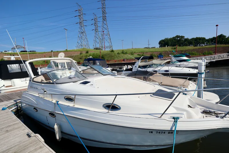 Slide: The Image of A 2003 Regal Commodore 2860 docked. It features a spacious deck and is surrounded by other boats. - 12