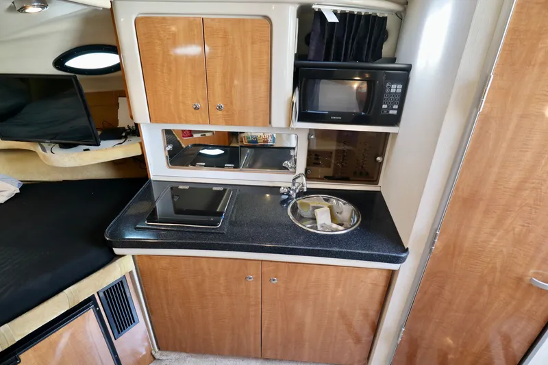 Slide: The Image of Compact galley with sink, stove, and microwave in a 2003 Regal Commodore 2860. - 15