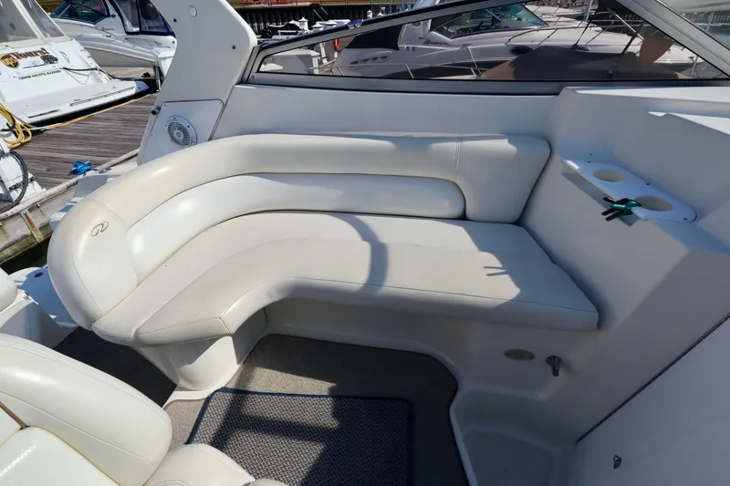 Slide: The Image of The image shows a white, cushioned seating area on a boat, surrounded by other boats in a marina. - 7