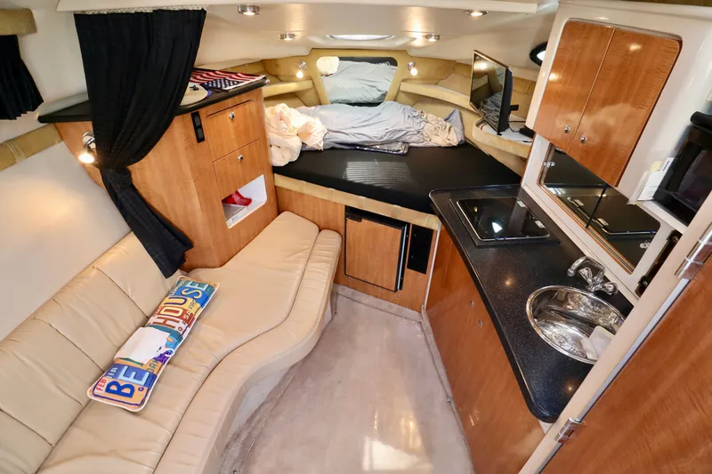 Slide: The Image of Interior of a 2003 Regal Commodore 2860 with a kitchenette, seating area, and sleeping space. - 1