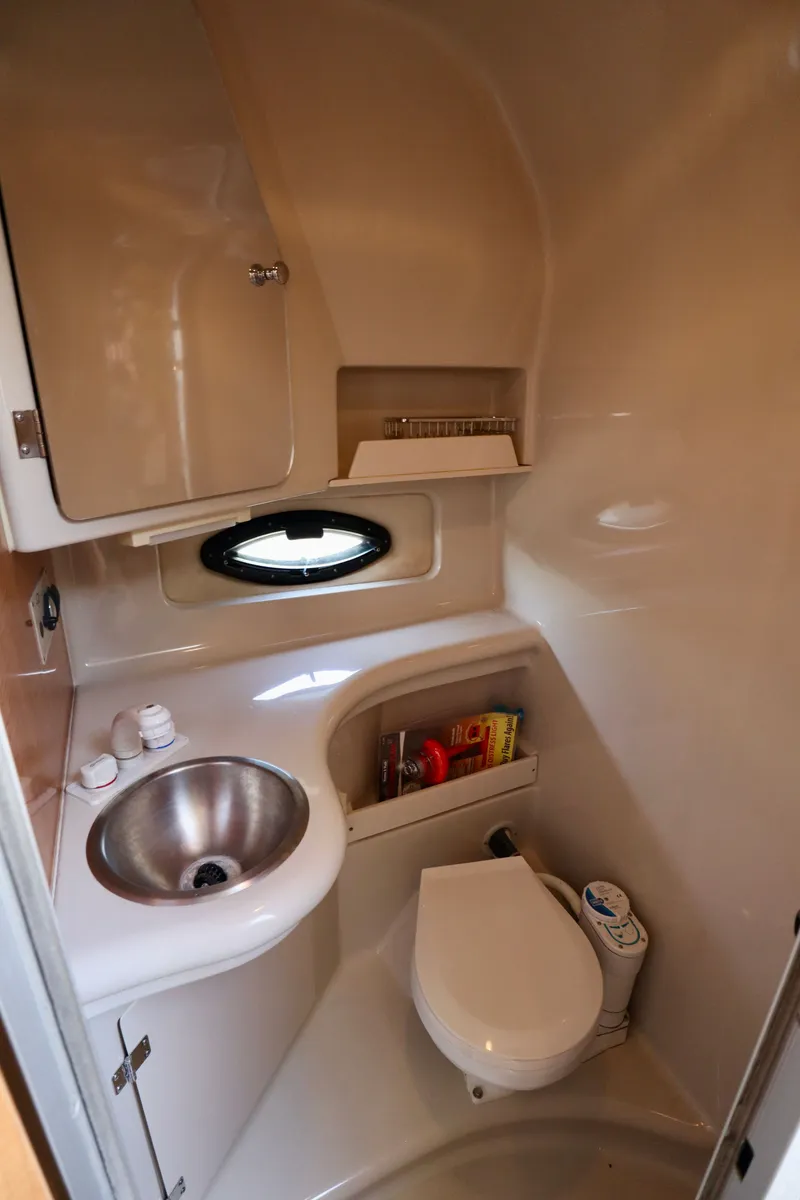 Slide: The Image of The image shows a compact boat bathroom with a sink, toilet, and storage space. - 13