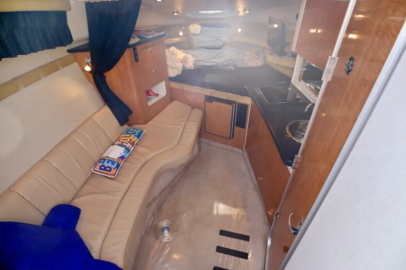 Slide: The Image of The 2003 Regal Commodore 2860 cabin features a cozy seating area, kitchenette, and a bed. - 14