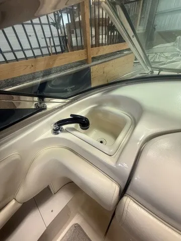 Slide: The Image of A sink with a faucet on a boat, surrounded by beige upholstery and windows. - 21