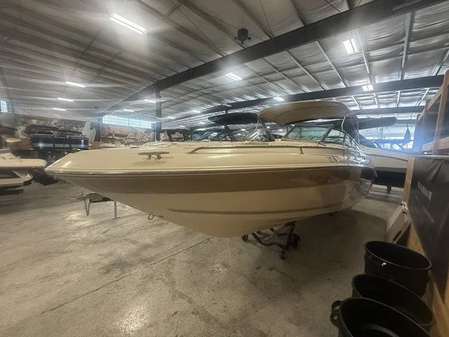 Slide: The Image of A 2001 Sea Ray 260 Signature in a warehouse. It features a beige exterior. - 10