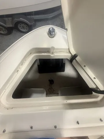 Slide: The Image of An open storage compartment on a 2001 Sea Ray 260 Signature boat, with a trailer in the background. - 12