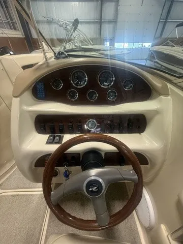 Slide: The Image of The image shows the cockpit of a 2001 Sea Ray 260 Signature with a sleek wood steering wheel and dashboard. - 9