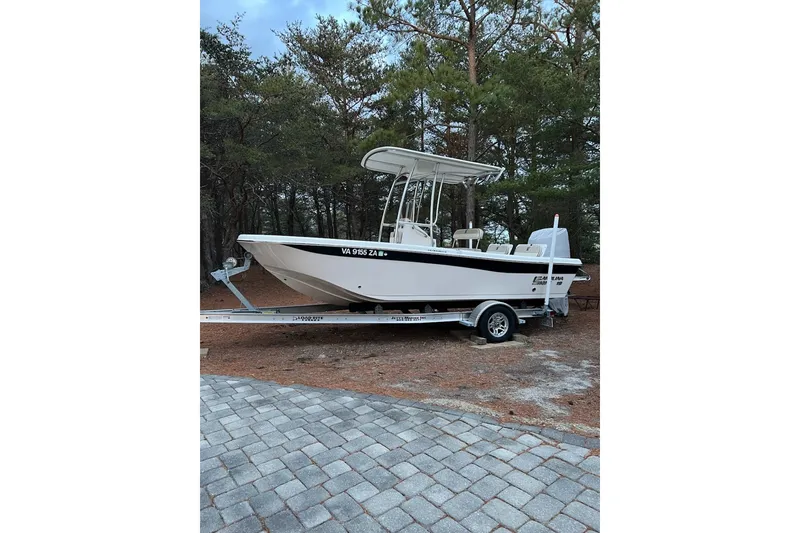 The Image of 2021 Carolina Skiff 19 Ultra Elite boat on trailer, parked near trees. - 1
