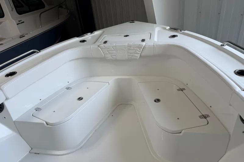 Slide: The Image of 2027 Parker 230 Coastal Elite boat interior with white seating and storage compartments. - 18