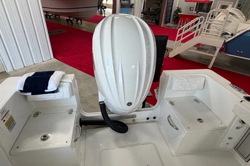 Slide: The Image of 2027 Parker 230 Coastal Elite boat interior with engine and seating, displayed indoors. - 8
