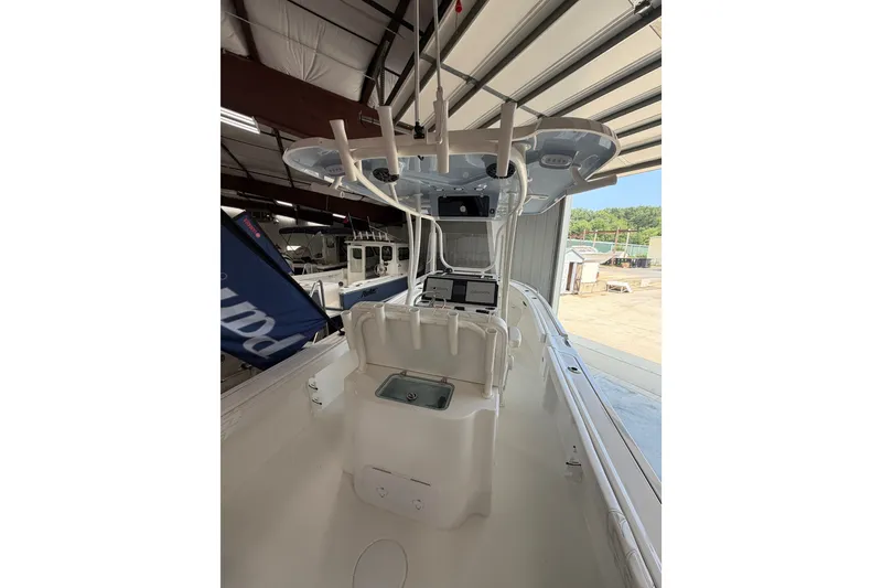 Slide: The Image of 2027 Parker 230 Coastal Elite boat interior with helm station in a storage facility. - 14