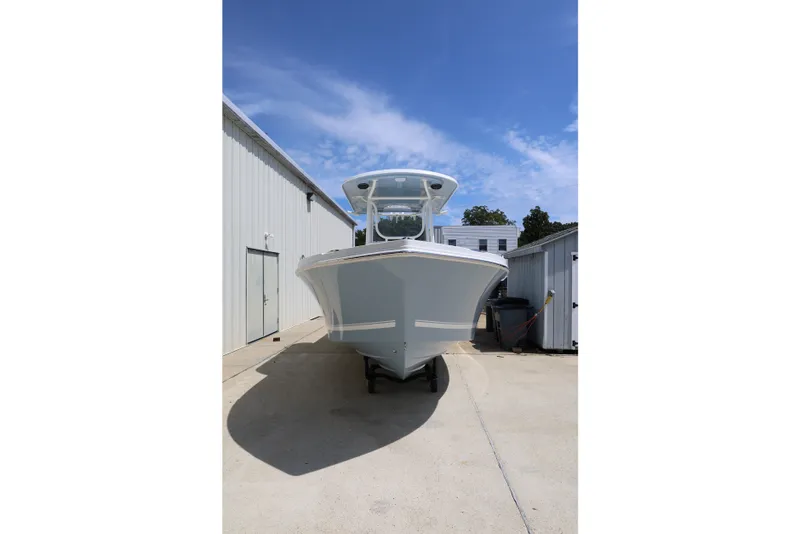 Slide: The Image of 2027 Parker 230 Coastal Elite boat in storage, front view under clear blue sky. - 4