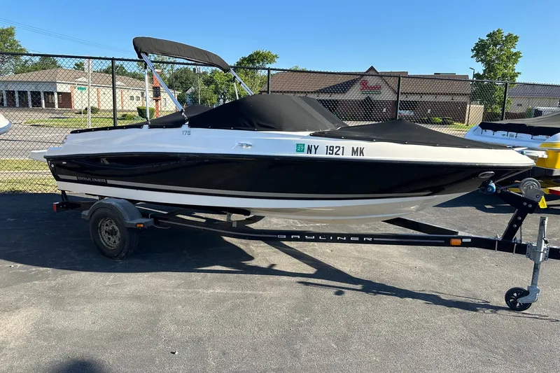 The Image of 2012 Bayliner 175 Bowrider boat on trailer, black and white, parked outdoors. - 0