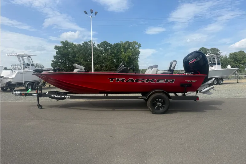 The Image of 2027 Tracker Pro Team 195 boat in vibrant red, parked outdoors on a trailer. - 1