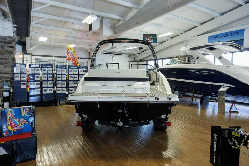 Slide: The Image of 2027 Sea Ray SPX 210 boat displayed in a showroom with wooden flooring. - 2
