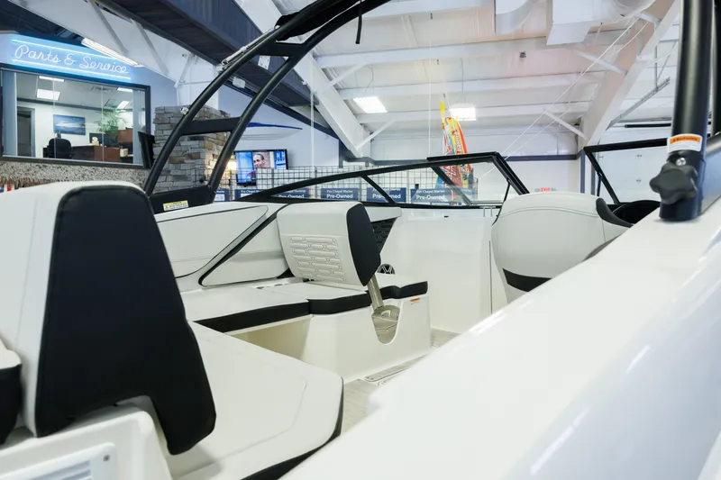 Slide: The Image of 2027 Sea Ray SPX 210 boat interior in showroom, featuring sleek seating and modern design. - 7