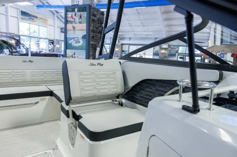 Slide: The Image of 2027 Sea Ray SPX 210 boat interior with sleek seating and modern design in showroom. - 16