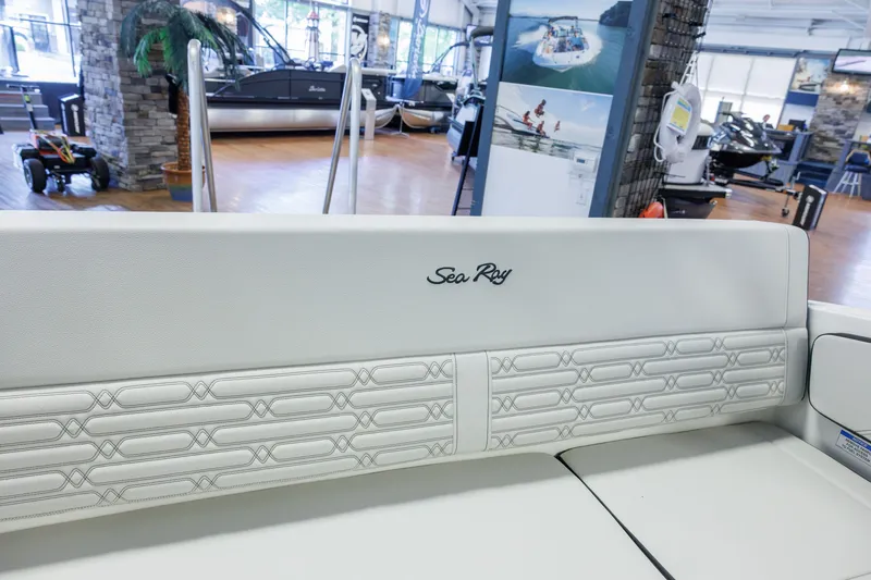 Slide: The Image of 2027 Sea Ray SPX 210 boat interior with elegant white seating in showroom. - 18