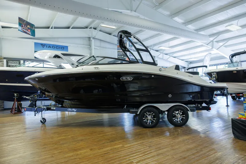 Slide: The Image of 2027 Sea Ray SPX 210 boat displayed indoors on a trailer in a showroom. - 1
