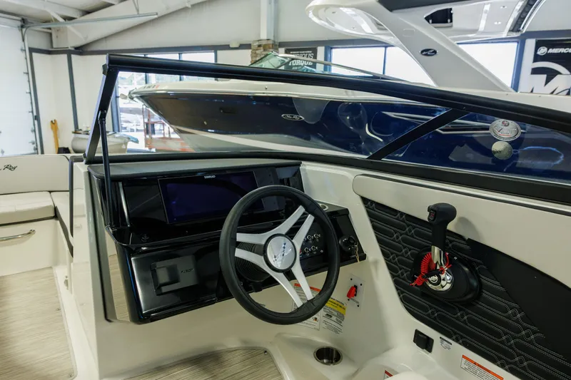 Slide: The Image of Interior view of a 2027 Sea Ray SPX 210 boat cockpit with steering wheel and controls. - 21