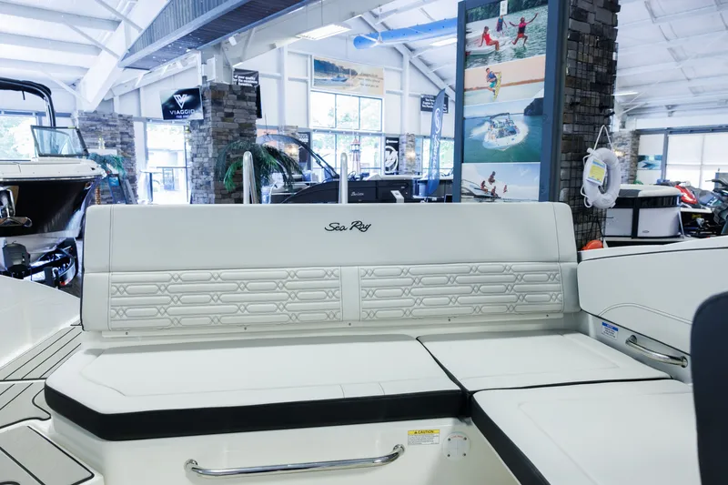 Slide: The Image of 2027 Sea Ray SPX 210 boat interior with elegant seating in a showroom setting. - 10