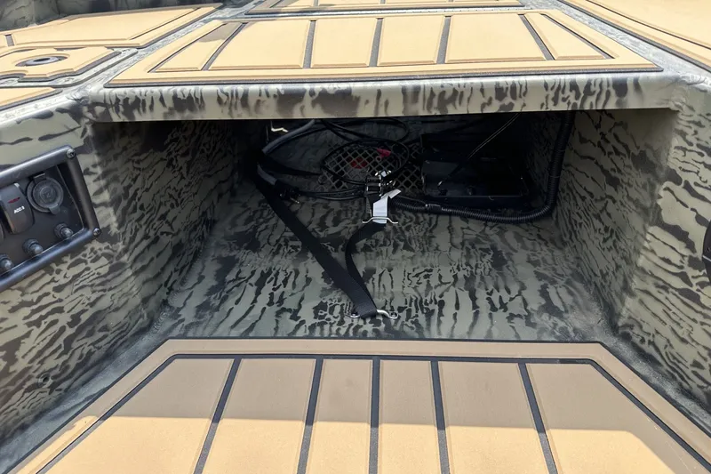 Slide: The Image of Interior view of 2026 Tracker Grizzly 1650 T Prairie Wings Edition boat, featuring camo design and storage area. - 16