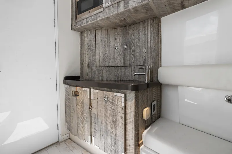 Slide: The Image of Interior of 2020 HCB 53 Suenos yacht featuring a compact kitchenette with rustic wood finish. - 61