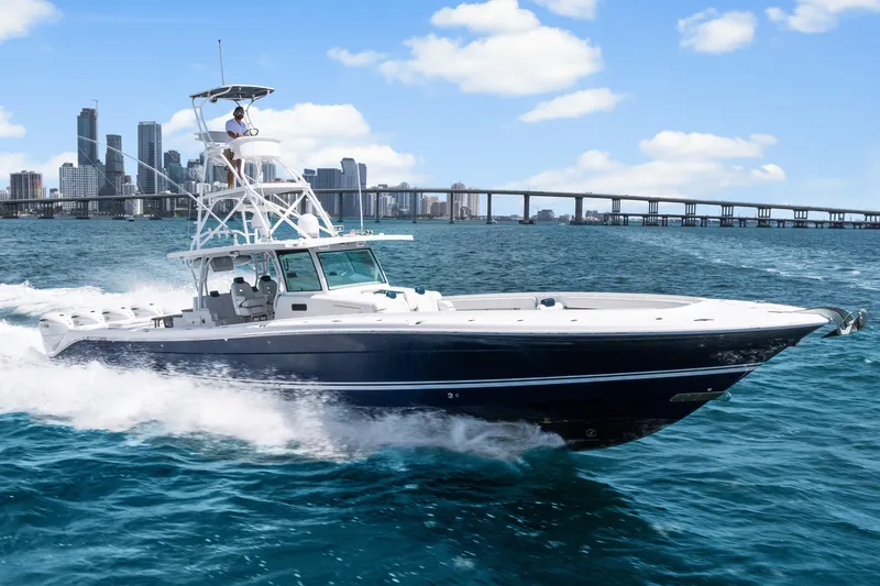 Slide: The Image of 2020 HCB 53 Suenos boat cruising on blue water with city skyline background. - 2