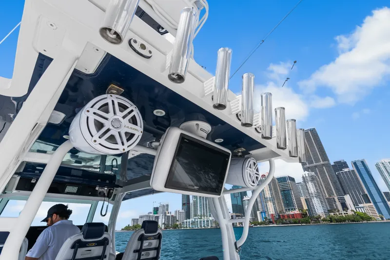 Slide: The Image of 2020 HCB 53 Suenos boat with speakers and rod holders, city skyline in background. - 58