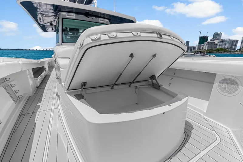 Slide: The Image of 2020 HCB 53 Suenos boat with open storage compartment, docked near city skyline. - 30