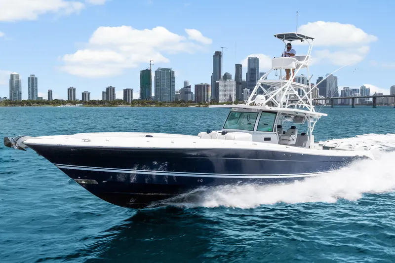 Slide: The Image of 2020 HCB 53 Suenos boat cruising on blue water with city skyline backdrop. - 16
