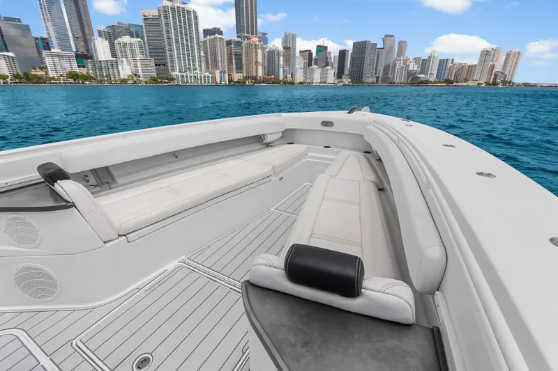 Slide: The Image of 2020 HCB 53 Suenos boat with luxurious seating, cruising near a city skyline. - 32