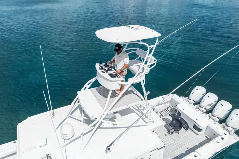 Slide: The Image of 2020 HCB 53 Suenos boat with elevated helm, cruising on clear blue water. - 24