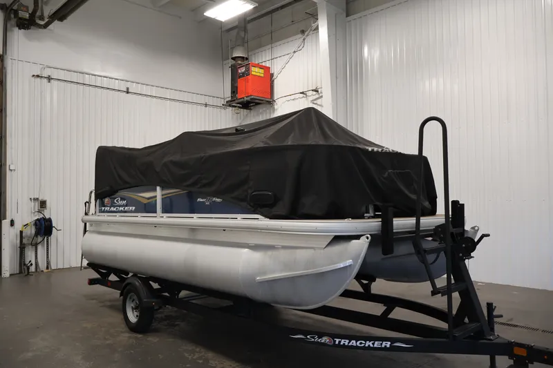 Slide: The Image of 2024 Sun Tracker Bass Buggy 16 XL pontoon boat covered in a garage. - 38
