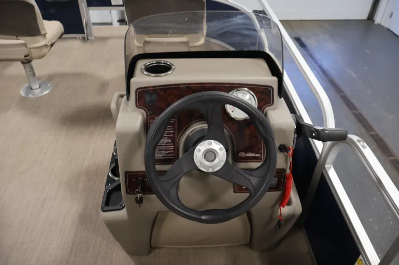 Slide: The Image of 2024 Sun Tracker Bass Buggy 16 XL steering console with gauges and controls. - 21