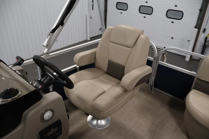 Slide: The Image of 2024 Sun Tracker Bass Buggy 16 XL captain's chair and steering wheel in a boat interior. - 25