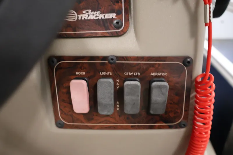 Slide: The Image of Control panel of 2024 Sun Tracker Bass Buggy 16 XL with switches for horn, lights, and aerator. - 23