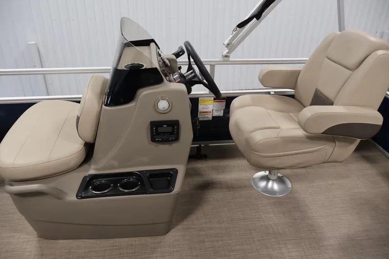 Slide: The Image of 2024 Sun Tracker Bass Buggy 16 XL boat interior with beige captain's chairs and control console. - 19