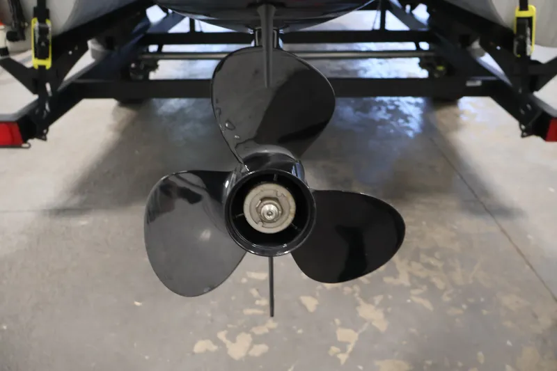 Slide: The Image of 2024 Sun Tracker Bass Buggy 16 XL boat propeller close-up in garage setting. - 34