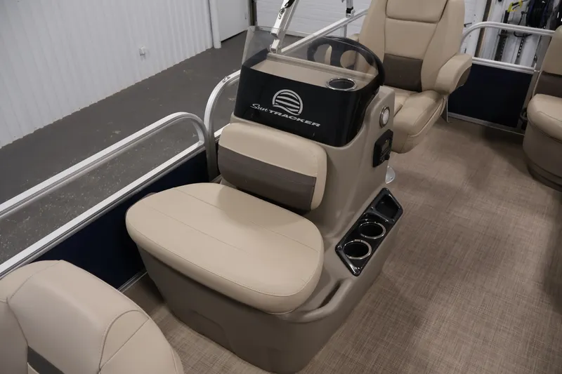 Slide: The Image of 2024 Sun Tracker Bass Buggy 16 XL interior with beige seating and steering console. - 16