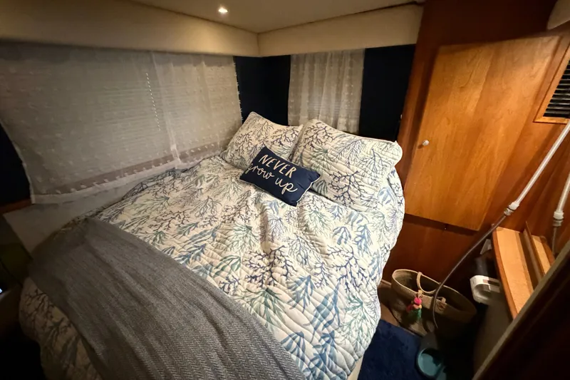 Slide: The Image of Cozy bedroom interior of 1998 Silverton 352 Motor Yacht with nautical-themed bedding. - 25