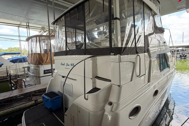 Slide: The Image of 1998 Silverton 352 Motor Yacht docked in a marina, featuring a covered upper deck. - 5