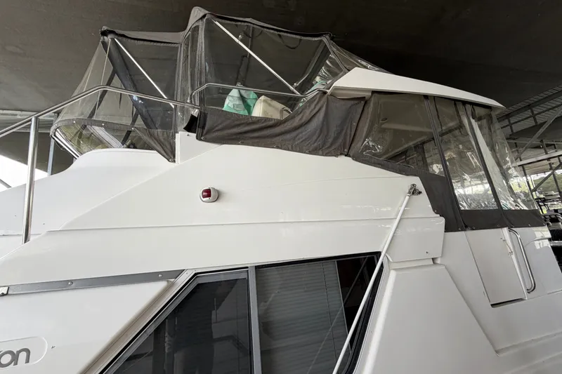 Slide: The Image of 1998 Silverton 352 Motor Yacht with enclosed upper deck, docked under shelter. - 3