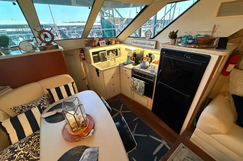 Slide: The Image of Interior of a 1998 Silverton 352 Motor Yacht with cozy kitchen and dining area. - 19